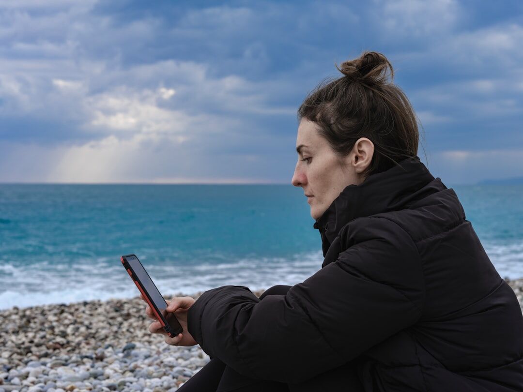 woman reading book by sea